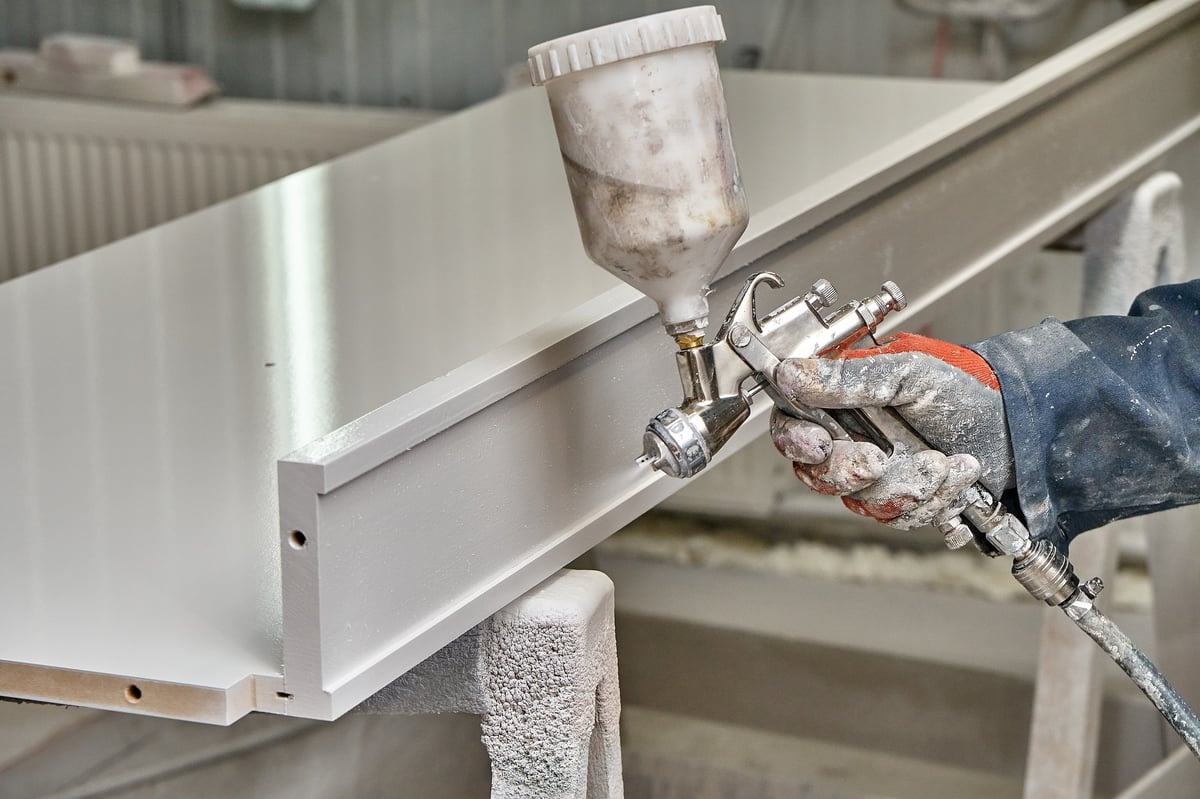 Spray painting cabinets in workshop
