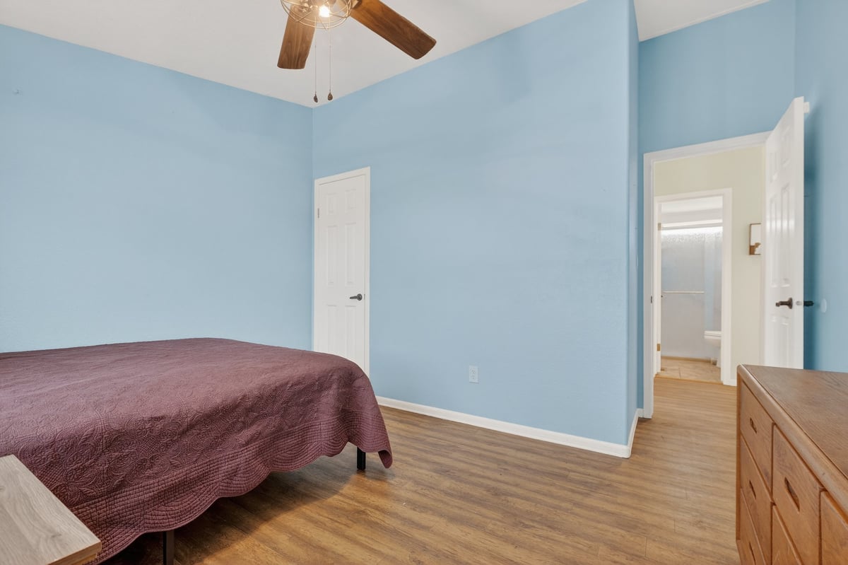 Freshly painted bedroom with light blue walls, white trim and hardwood floors